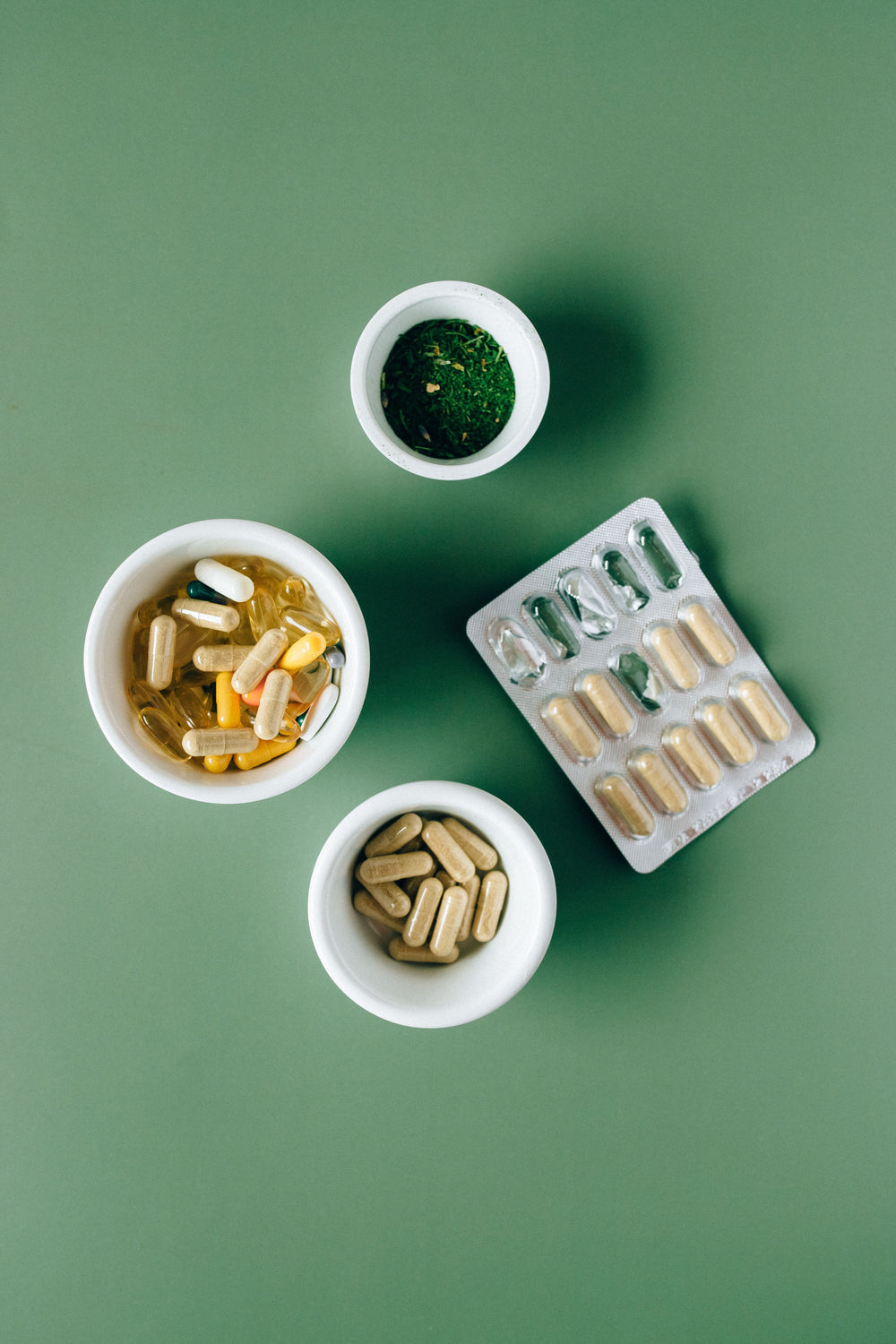 Doxwell Shatavari Gold Capsules – herbal capsules in bowls on green surface