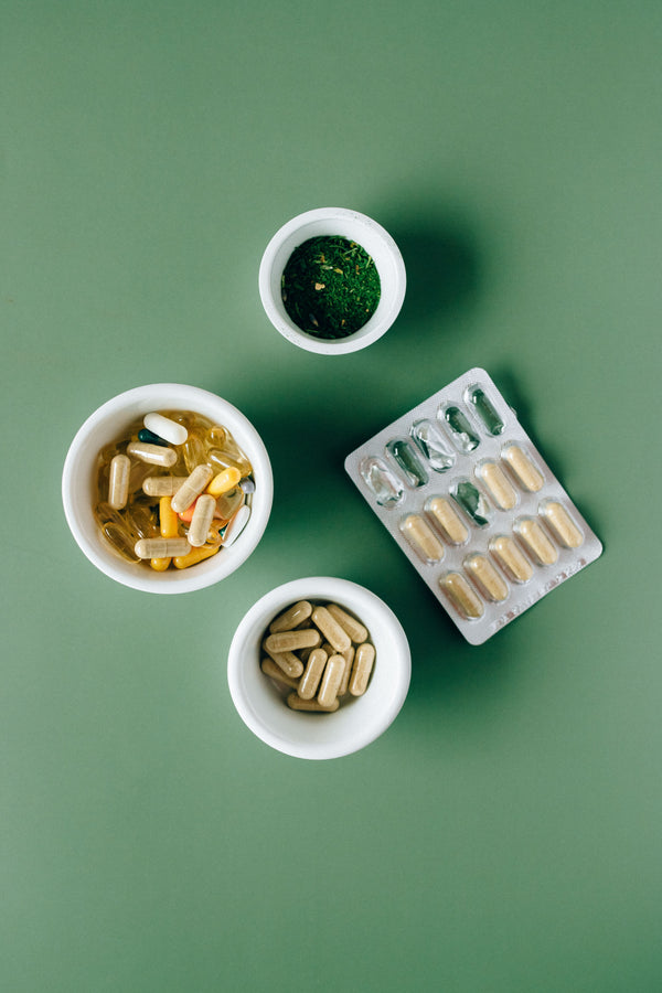Doxwell Shatavari Gold Capsules – herbal capsules in bowls on green surface