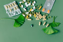 Doxwell Sehat Vati – natural supplements with ginkgo leaves on green surface